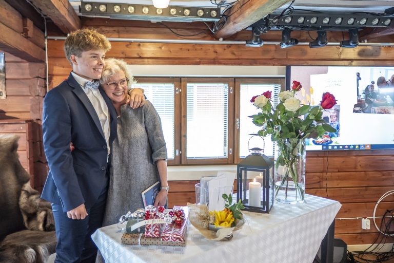 Isoäiti halaa rippilasta Raikku Ranchin juhlatilassa.